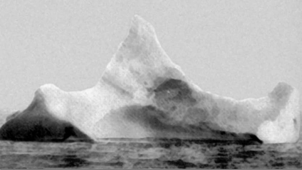 Тот самый айсберг, который проделал в корпусе «Титаника» 100-метровую пробоину. Фотограф с другого судна заметил длинную полосу красной краски на айсберге