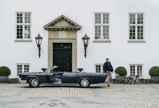 Андерс Кирк Йохансен со своим Lincoln Continental 1967 года и стародатским пойнтером Пеппи у главного дома в поместье Роден Годз