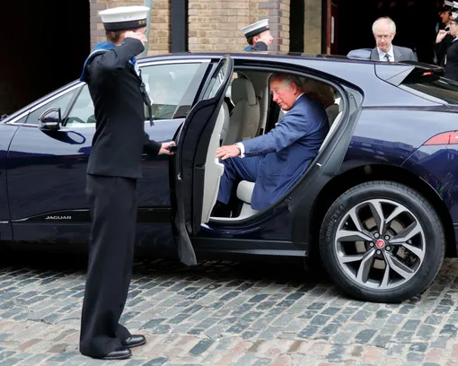 Карл III садится в Jaguar I-PACE с шофером после посещения недавно отремонтированной яхты «Maiden» на верфи HMS President 5 сентября 2018 года в Лондоне