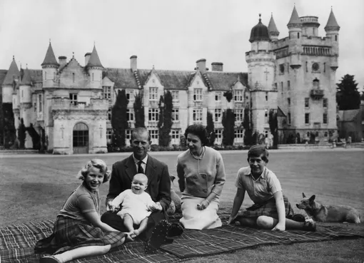 Королева Елизавета Вторая и принц Филипп, герцог Эдинбургский, со своими детьми принцем Эндрю (в центре), принцессой Анной (слева) и Чарльзом (справа) на пикнике возле замка Балморал. 8 сентября 1960.