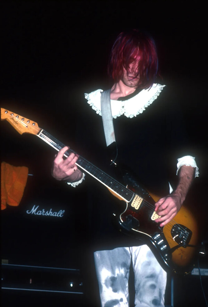 Курт Кобейн в платье с белым воротничком во время выступления группы Nirvana
