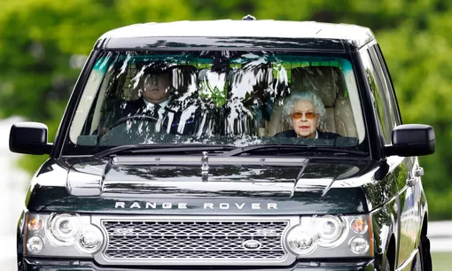 Королева Елизавета II отправляется на своем автомобиле Range Rover с шофером, чтобы посмотреть, как ее лошадь Балморал Лея соревнуется и побеждает в классе Хайленд на второй день Королевского конного шоу в Виндзоре в Хоум-парке