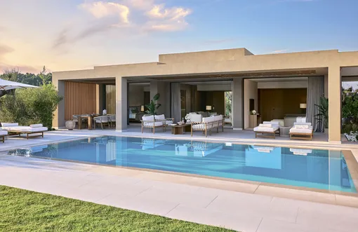 Внутреннее пространство виллы переходит в приватный сад с бассейном, что создаёт атмосферу уединения и комфорта